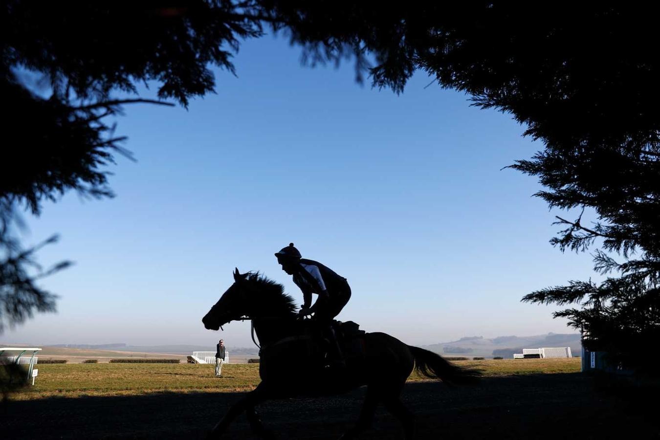 Jinete montando un caballo en los establos en Lambourn, Berkshire, al oeste de Londres