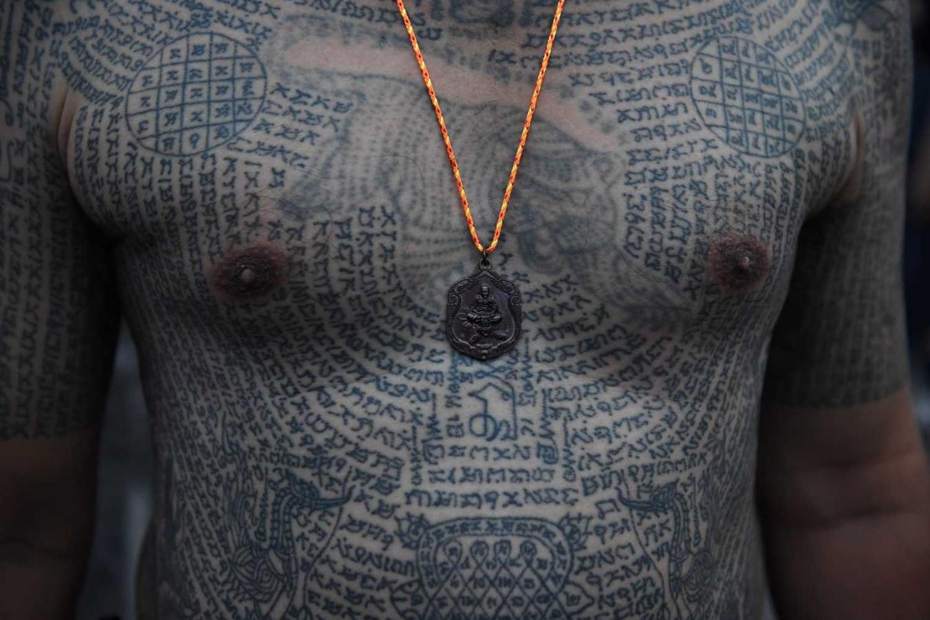 Detalle del tatuado cuerpo de un devoto Budista, durante el festival de los tatuajes sagrados en el tempo Wat Bang Phra, Tailandia 