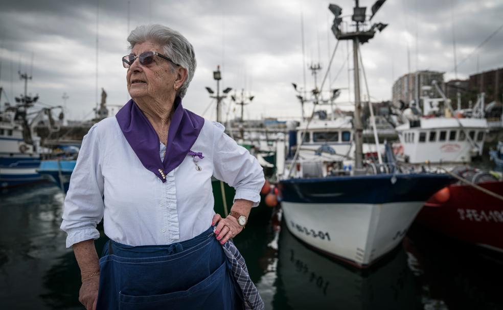 Begoña Martínez, de 88 años, posa frente a los pesqueros amarrados en el puerto de Santurtzi.