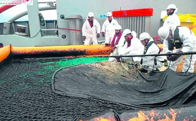 Labores de limpieza del fuel vertido por el mercante desde el buque galo 'Argonaute'.