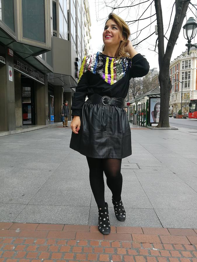 Sudadera de lentejuelas con falda de cuero para conseguir looks más sofisticados.