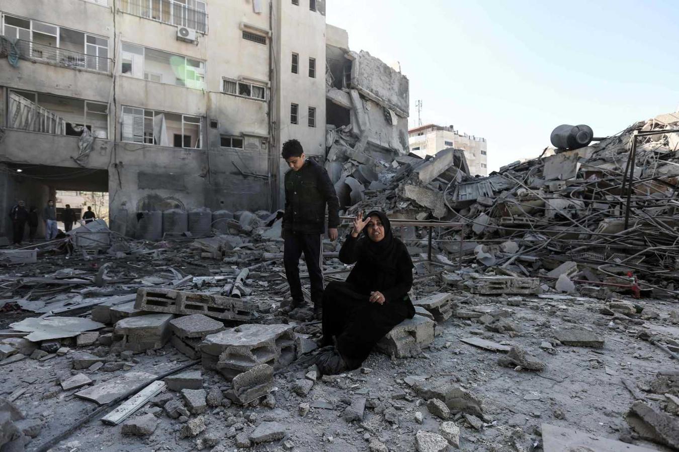 Una mujer palestina sentada sobre los escombros de un edificio, después de los ataques aéreos israelíes contra la Franja de Gaza