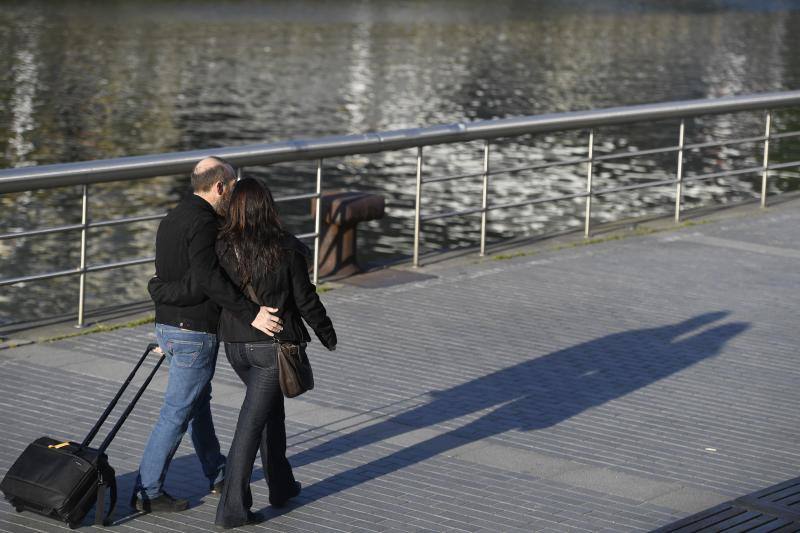 Una pareja pasea junto a la ría.