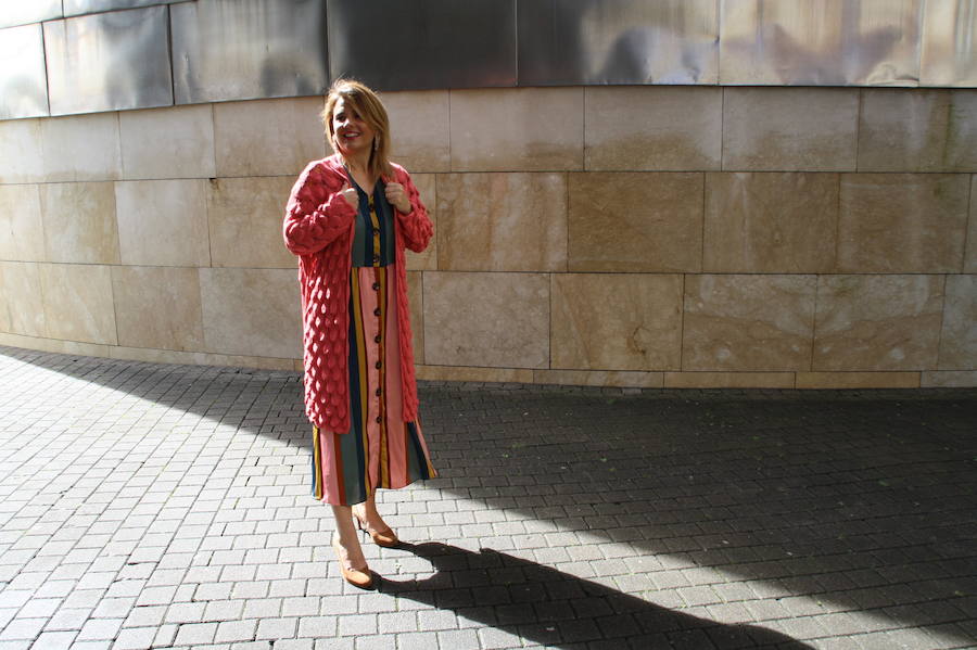 Un vestido coral a rayas con chaqueta de punto, un look divertido y alegre.