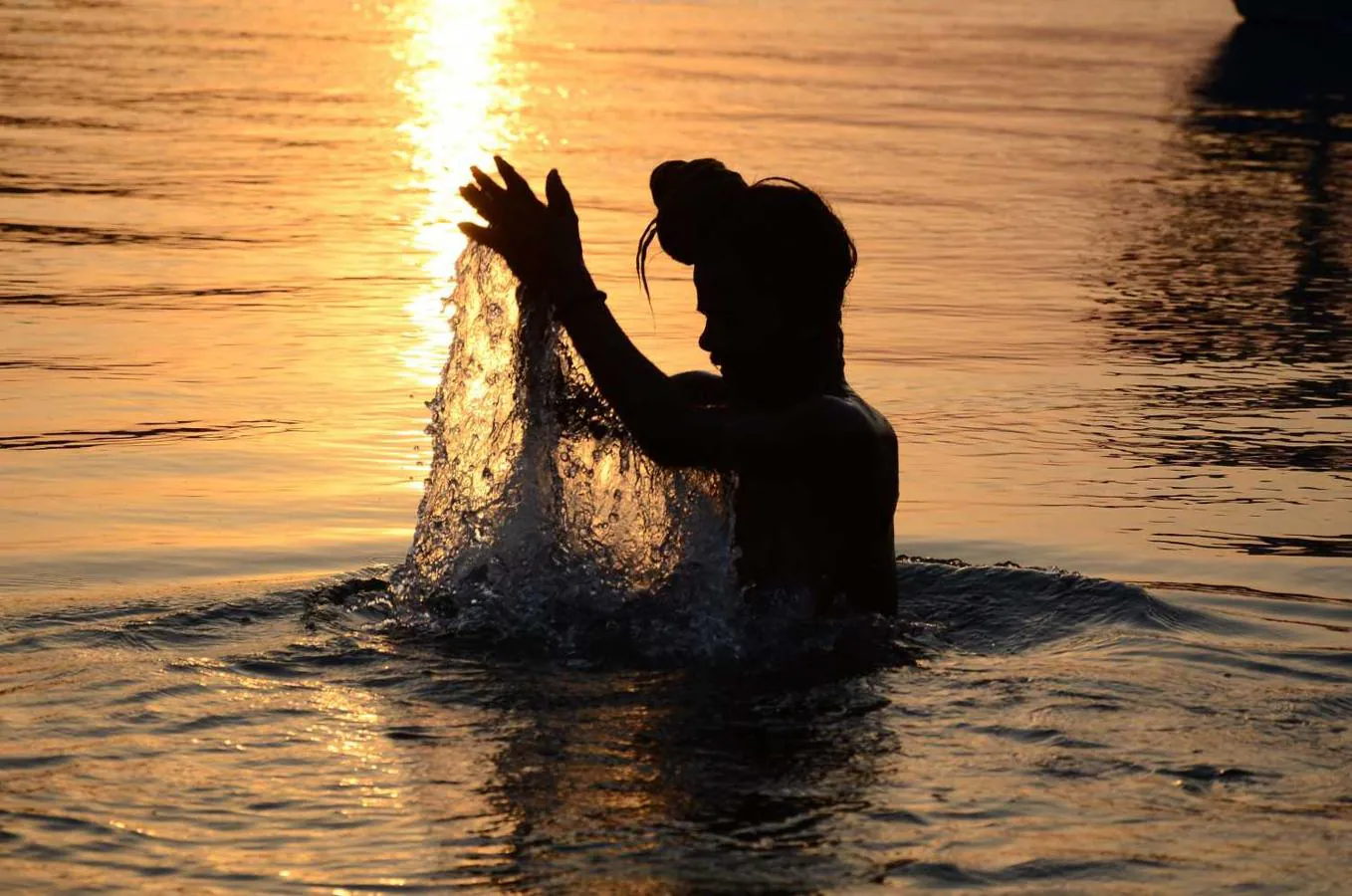 Un devoto hindú se baña en el río Narmada durante el amanecer en Gwarighat en Jabalpur