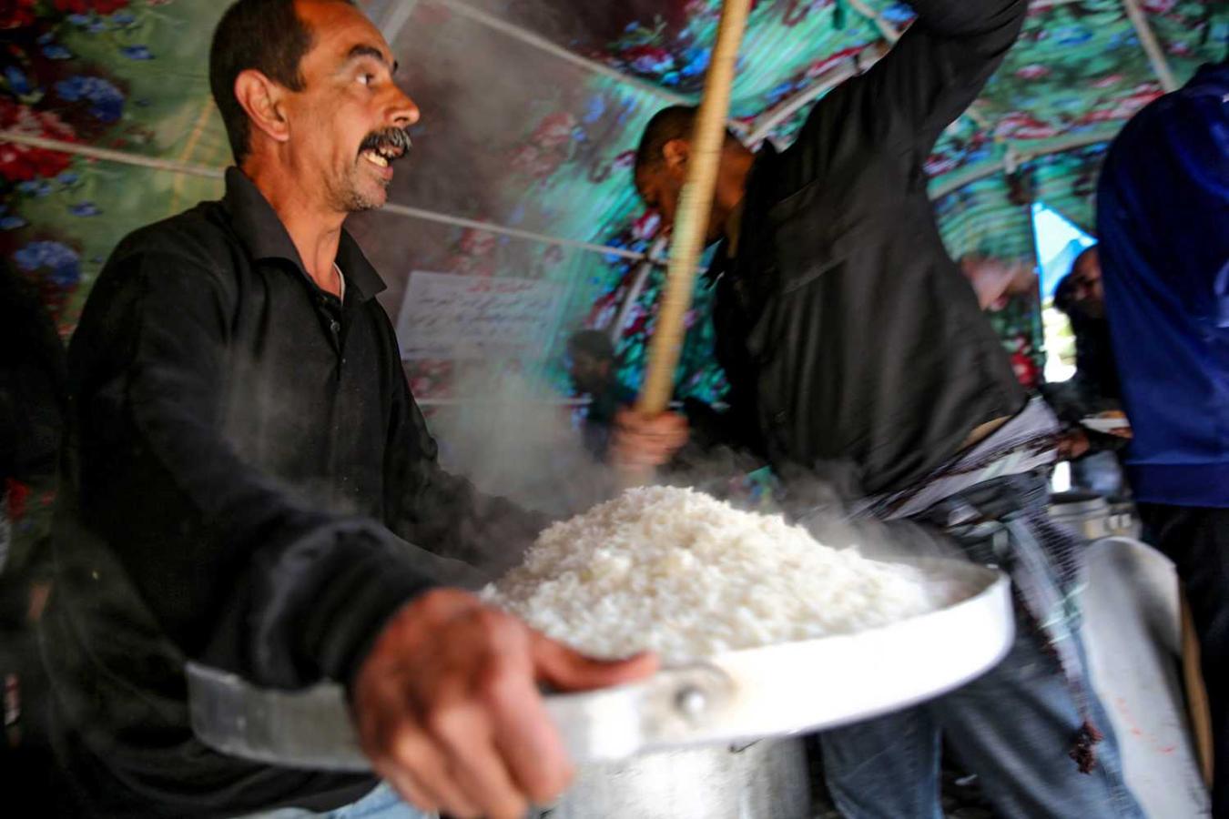 Hombres preparan y distribuyen comida entre los peregrinos musulmanes chiíes en el centro de Bagdad, Irak , dentro de los actos que marcan el aniversario del séptimo imán chiíta, Musa al-Kadhim 