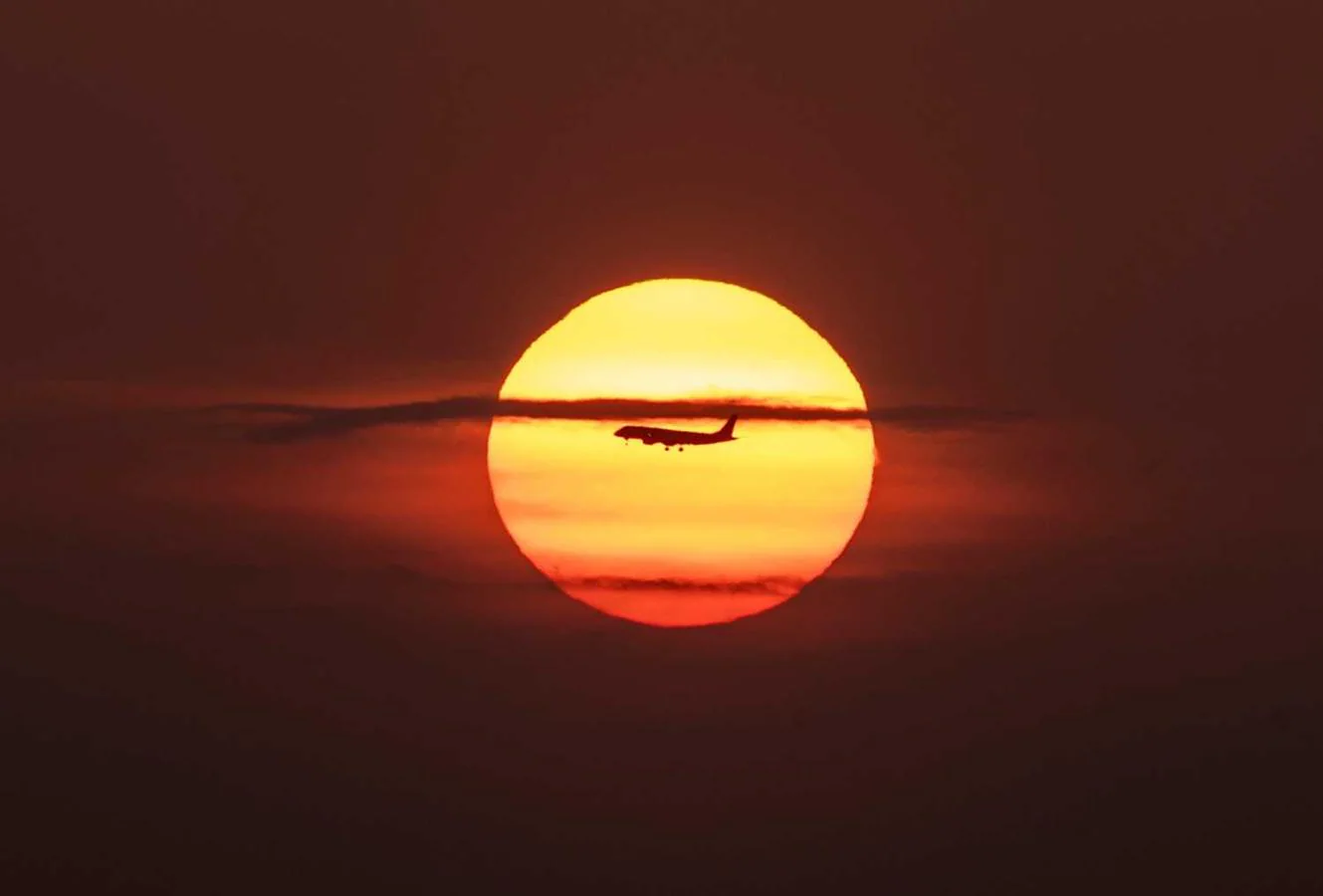 La silueta de un avión se recorta ante el sol en Panamá