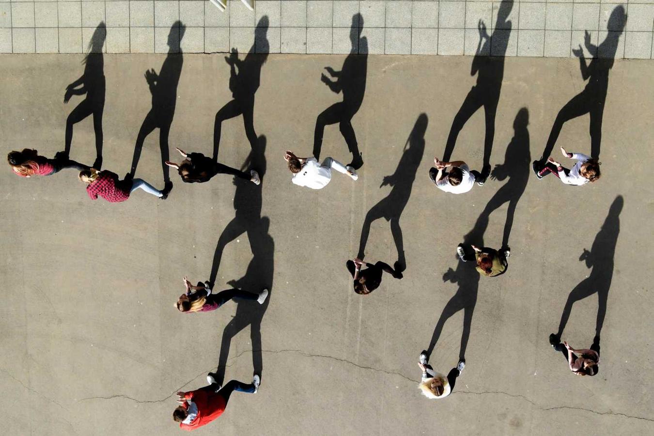 Jóvenes realizan una coreografía al aire libre en un día soleado en el centro de Moscú 