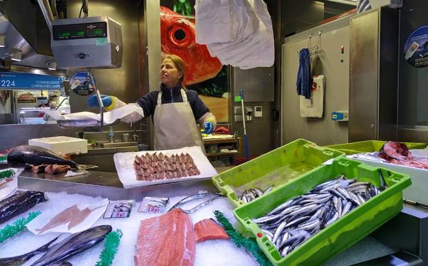 Ana María Lozano limpia anchoas en su puesto de La Ribera, 'Pescados Ana'.