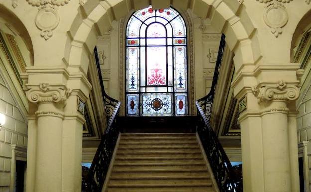 Al fondo de la escalinata de la biblioteca.