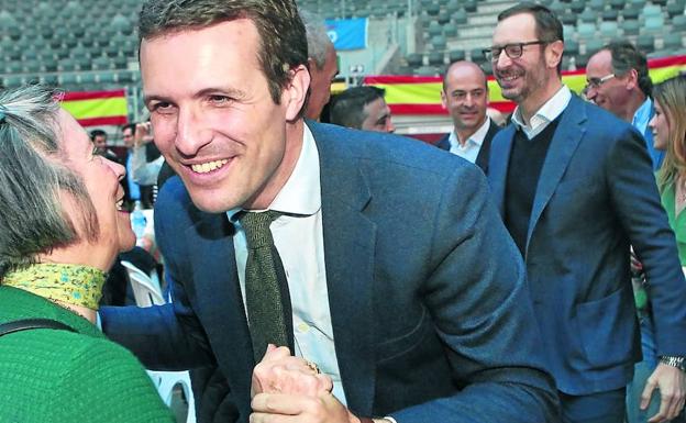 Casado saluda a una simpatizante a su llegada a la plaza de toros, con Maroto a su espalda.