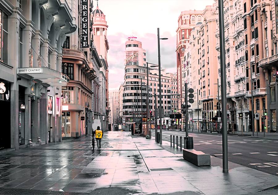 Un repartidor con bicicleta es la única presencia en una Gran Vía de Madrid completamente desierta. 