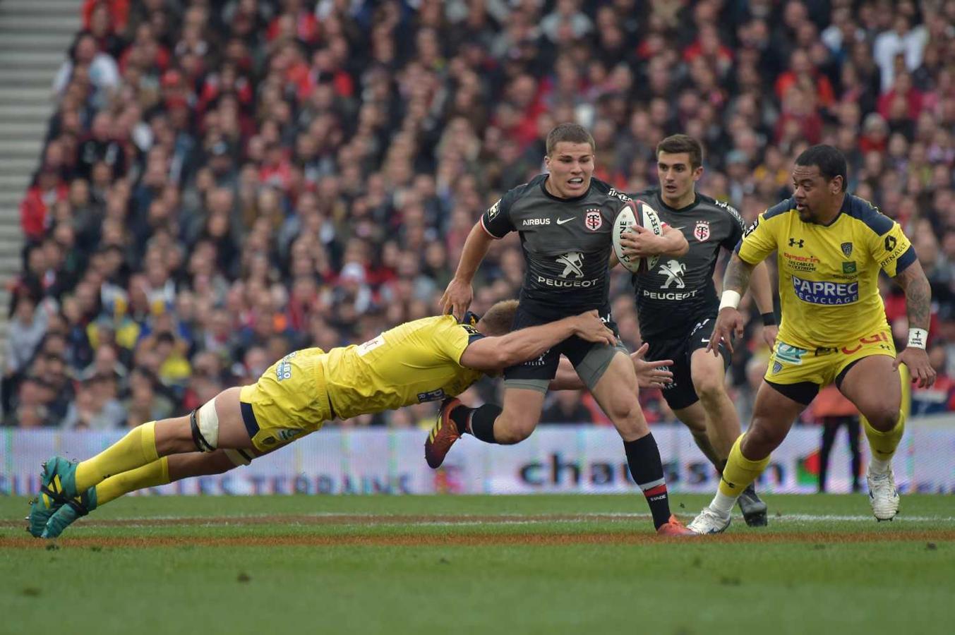 El jugador del Toulouse Antoine Dupont (C) se lleva el balón, pese a la presión de los contrincantes del Clermont John Ulugia (R) y el sudafricano de Clermont Jacobus Van Tonder (L) en el Estadio Municipal en Toulouse