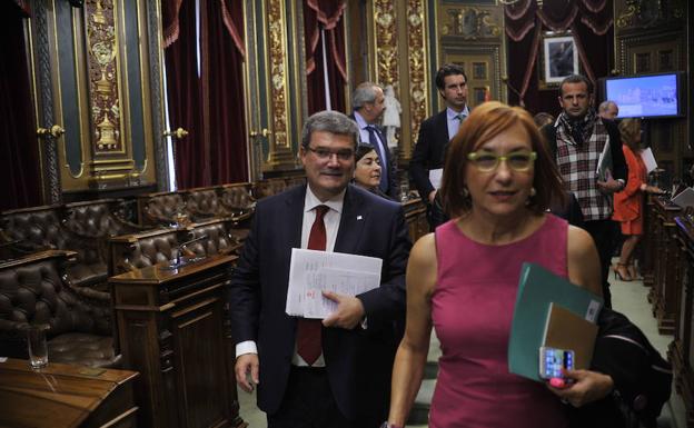 La portavoz de UdalBerri, Carmen Muñoz, abandona el salón de plenos por delante del alcalde, Juan Mari Aburto. 