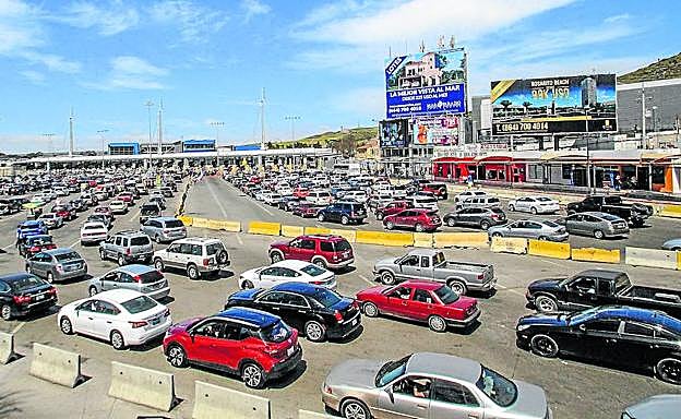 Paso fronterizo en Tijuana, con vallas publicitarias entre las que destaca una clínica de cirugía estética. 