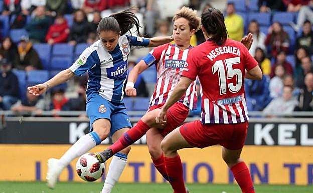 Una jugadora local tratando de controlar el balón ante dos rivales. 