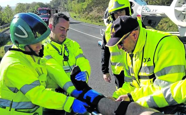 Miembros del equipo médico del helicóptero de Osakidetza atienden a un accidentado en la carretera.