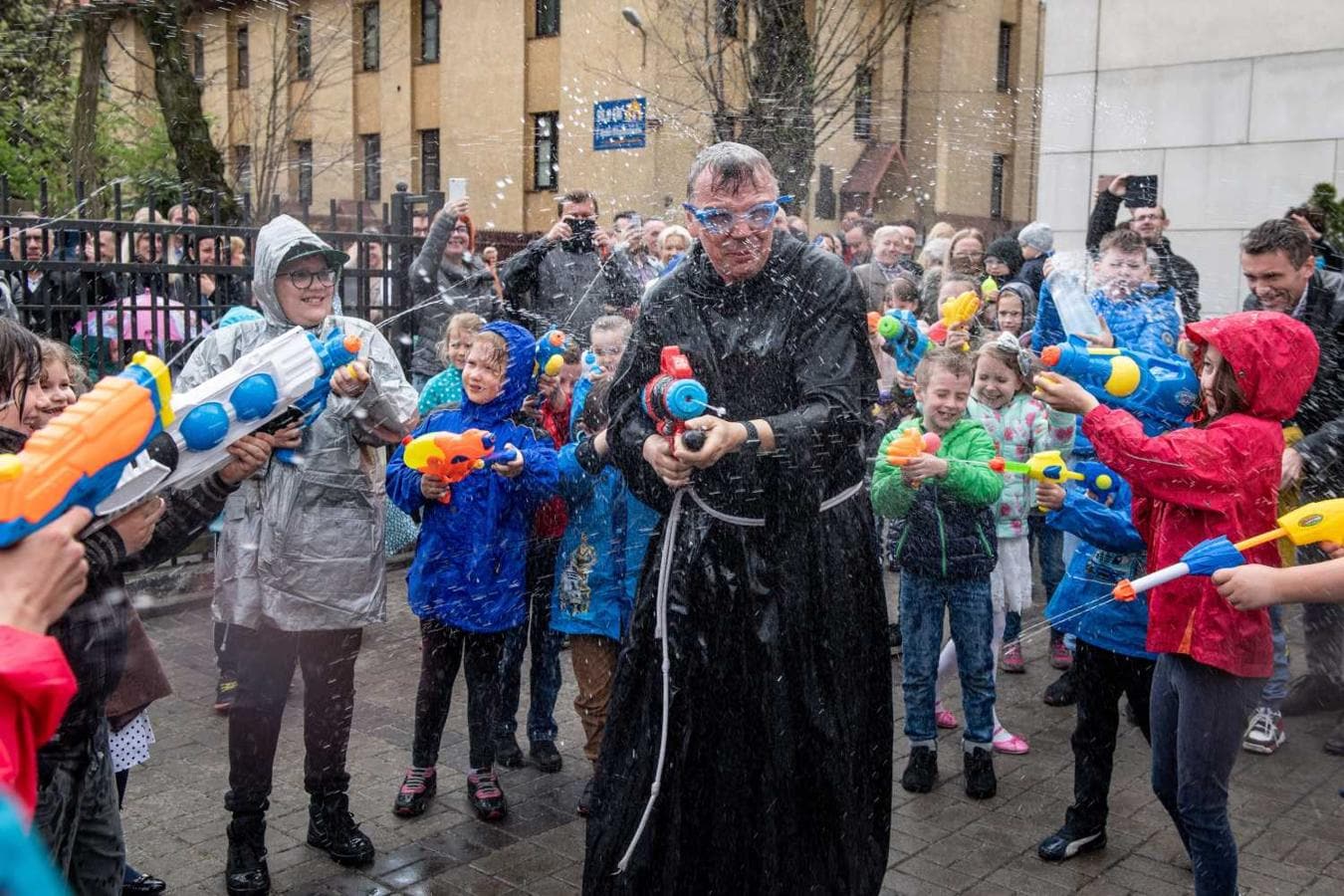 El padre Piotr Kleszcz (c), sacerdote de la parroquia Nuestra Señora de los Ángeles de Lódz, juega con varios niños durante la tradicional celebración del "Smigus-dyngus", también conocido Lunes Mojado, en Lódz (Polonia). 