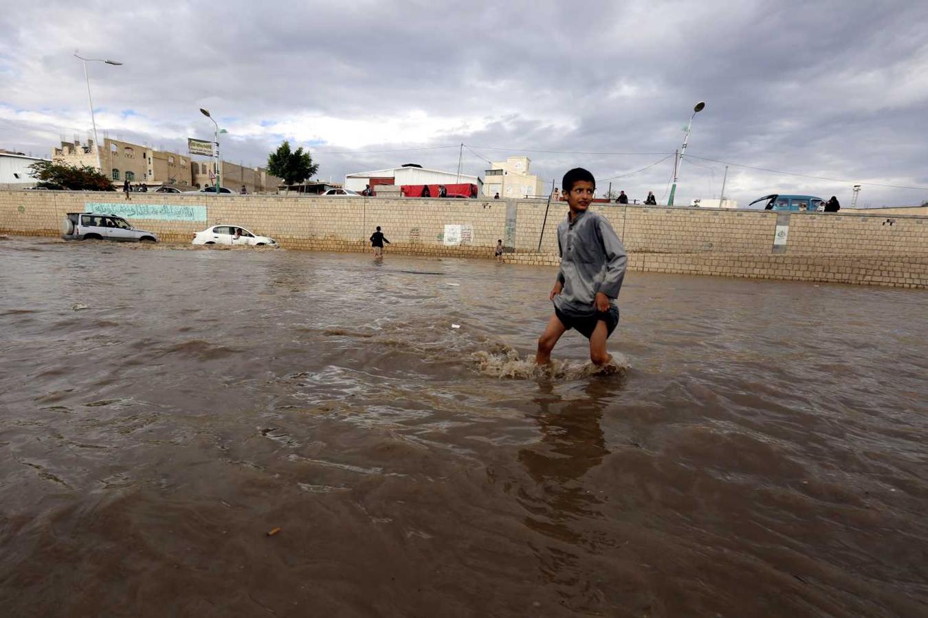 Un niño camina por una carretera inundada después de fuertes lluvias, en Saná (Yemen). 