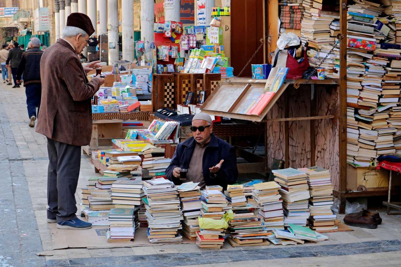 Un hombre vendiendo libros en su puesto de la calle Mutanani, en Bagdad, Irak