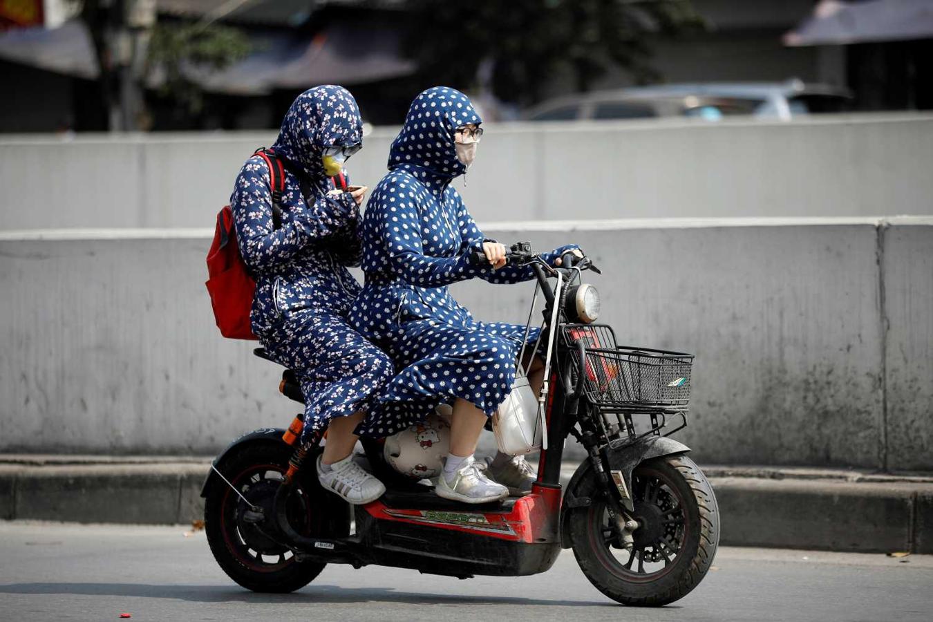 Dos mujeres usan ropa para protegerse del calor y el sol mientras conducen por una calle de Hanói (Vietnam). El norte y el centro de Vietnam se vieron afectados recientemente por un extremo clima caliente, con las temperaturas que alcanzaron más de 40 grados centígrados, según el Centro Nacional para el Pronóstico Hidro-meteorológico. 