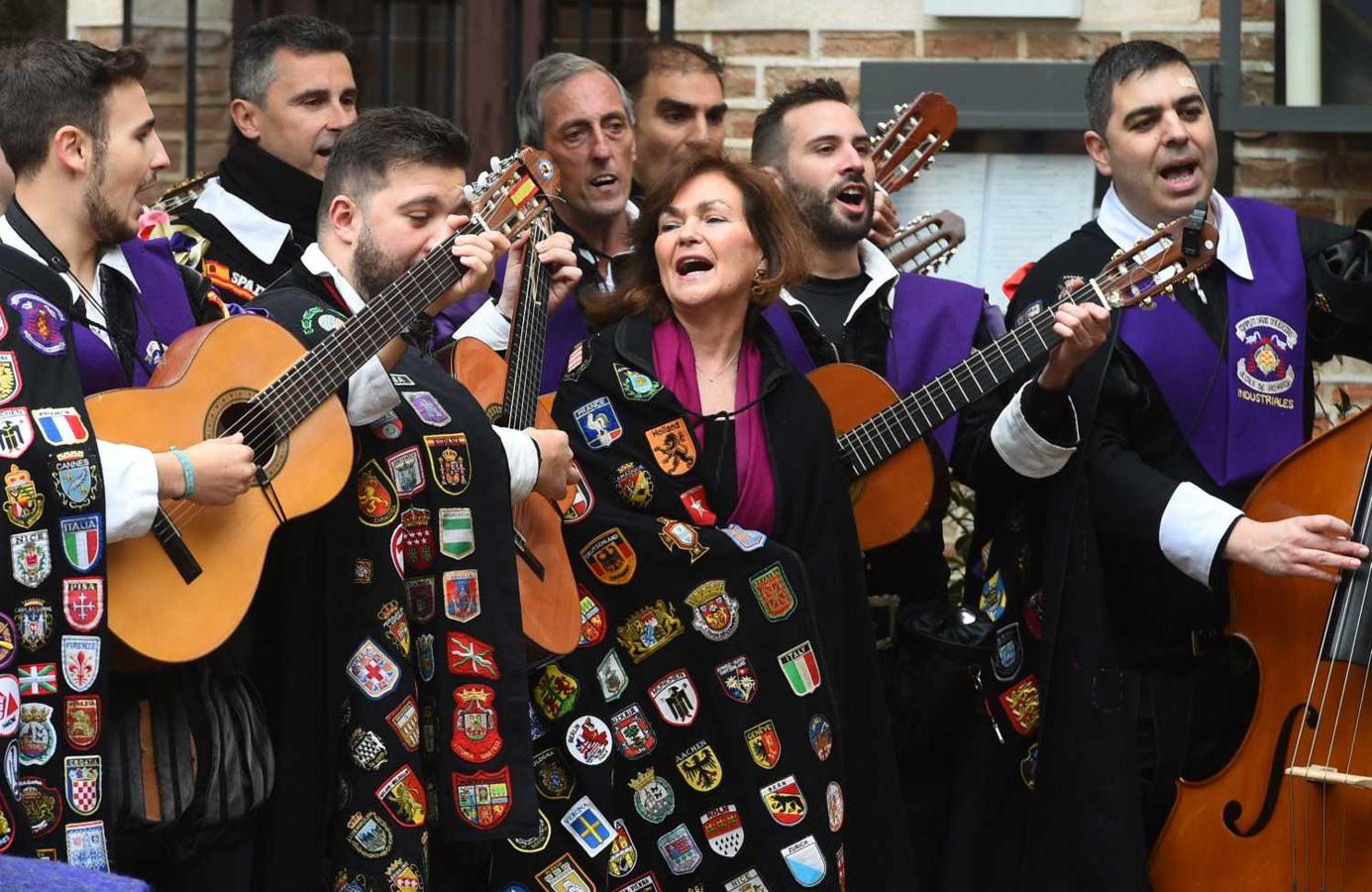 La vicepresidenta del Gobierno, Carmen Calvo, viste una capa de la tuna de la Universidad de Alcalá junto a varios de sus miembros, tras la entrega del Premio de Literatura en Lengua Castellana Miguel de Cervantes 2018 a la poeta uruguaya Ida Vitale
