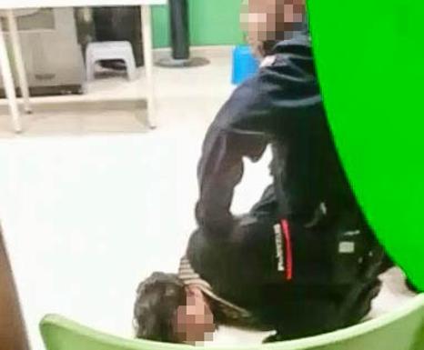 Un ertzaina inmoviliza al joven dentro de la lavandería de Coronación.