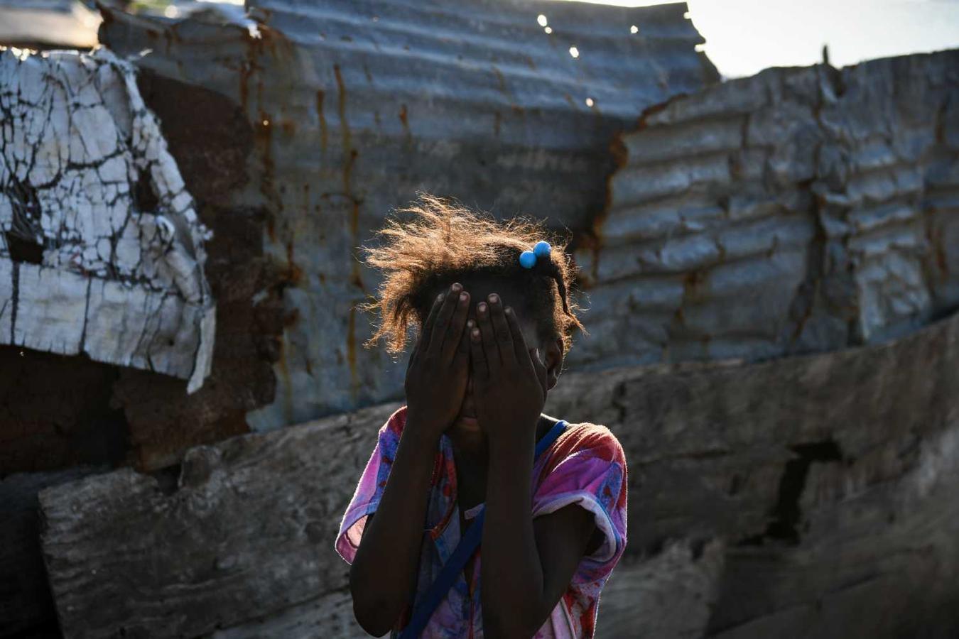 Una niña se tapa la cara cerca de su casa en Puerto Príncipe, Haití 