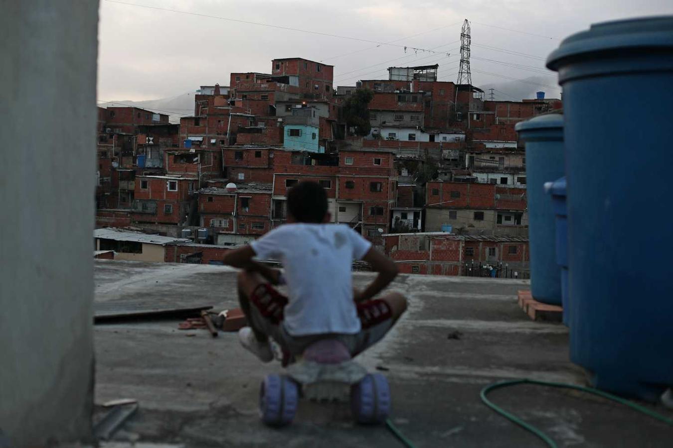 Andrew monta un pequeño triciclo en la azotea de la casa de su familia en el barrio de Catia en Caracas, Venezuela.