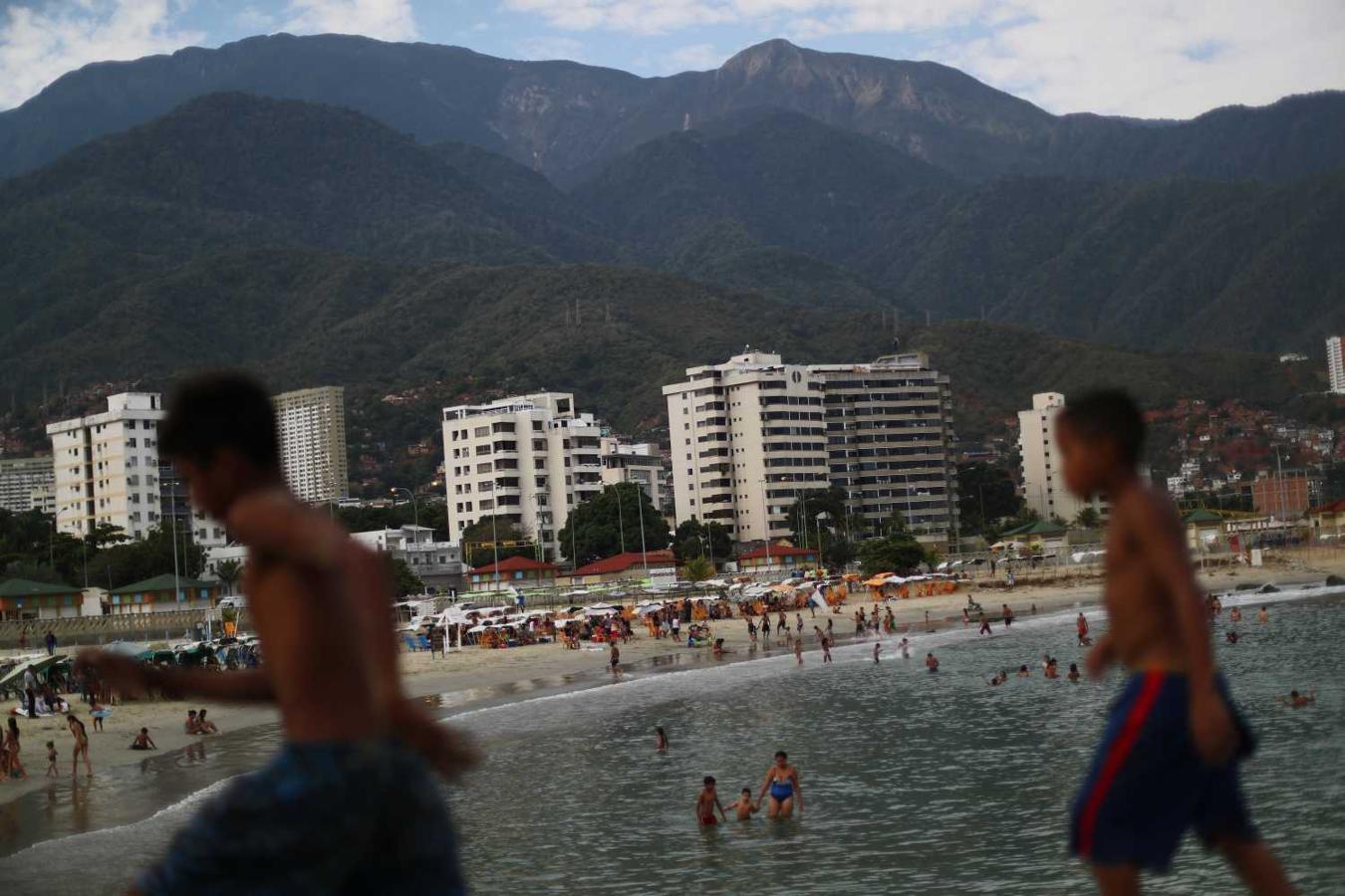 Los niños caminan a lo largo de un rompeolas en la playa Coral en La Guaira, cerca de Caracas, Venezuela. "Una persona que tiene un salario mínimo no puede venir [a la playa]. La angustia que tienen todos los venezolanos es la comida. Primero la harina y el arroz. dijo Carla Córdova.