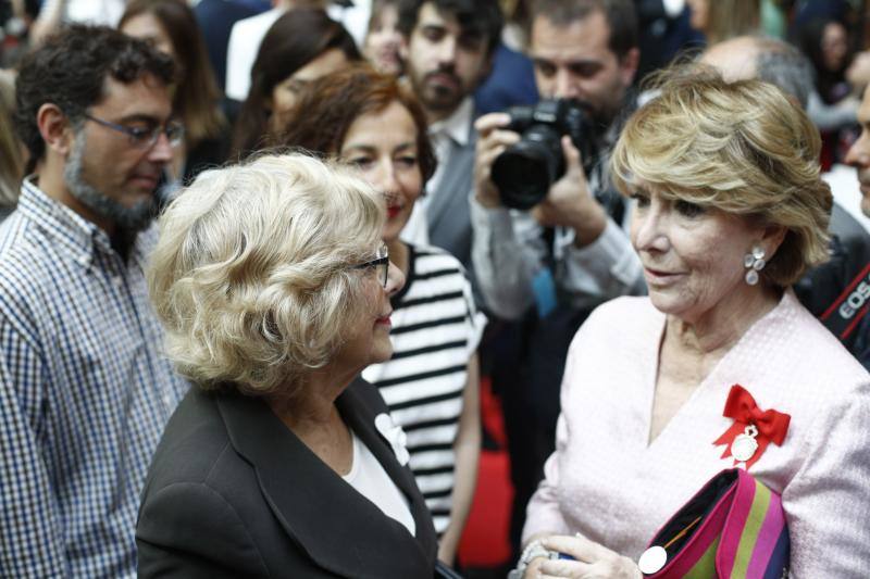 La expresidenta de la Comunidad de Madrid, Esperanza Aguirre, y la alcaldesa de Madrid, Manuela Carmena, se saludan antes del acto de imposición de la Medalla de la Comunidad de Madrid y de las Condecoraciones de la Orden del 2 de Mayo a los premiados.