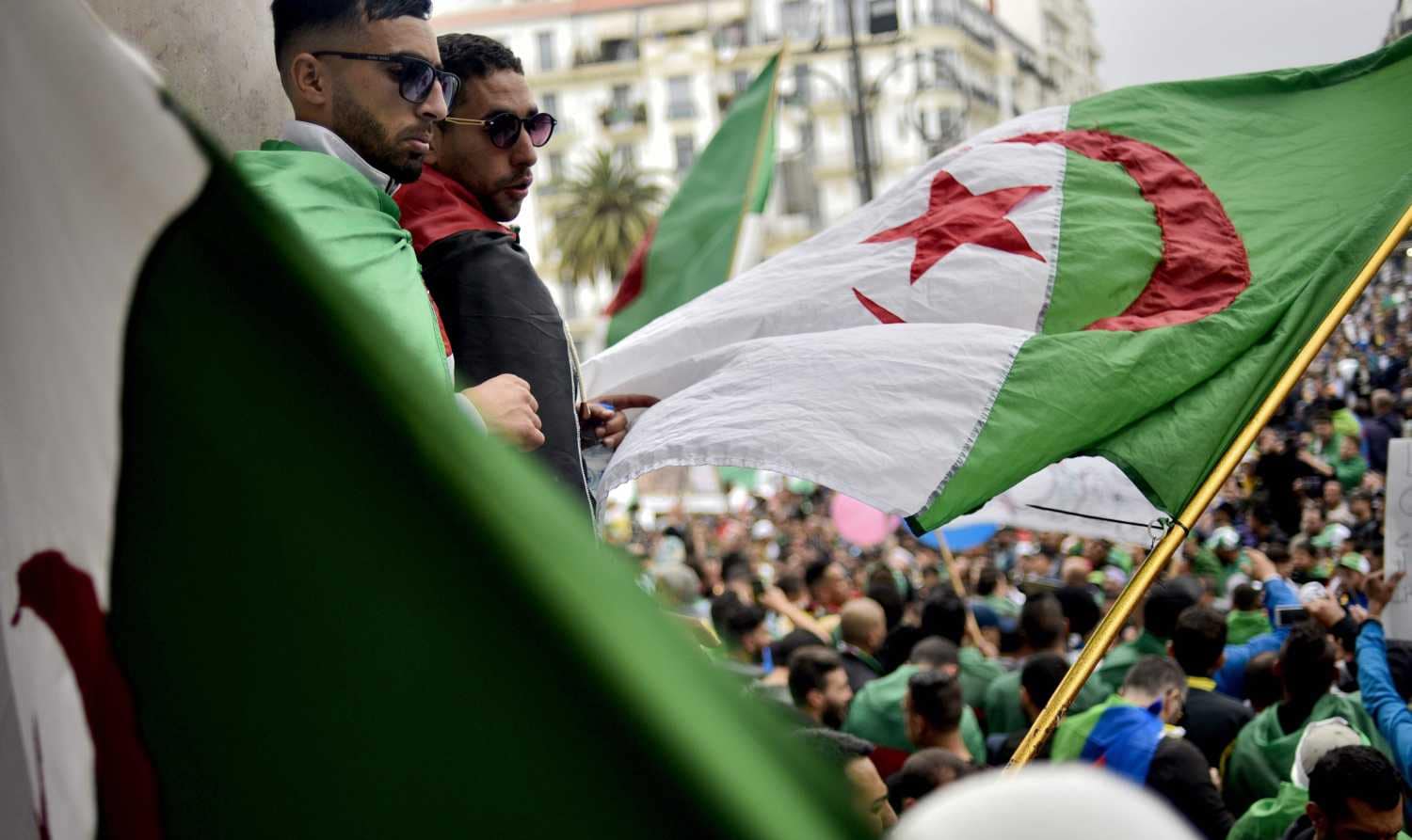 Manifestantes argelinos ondean una bandera nacional mientras participan en una manifestación en la capital, Argel