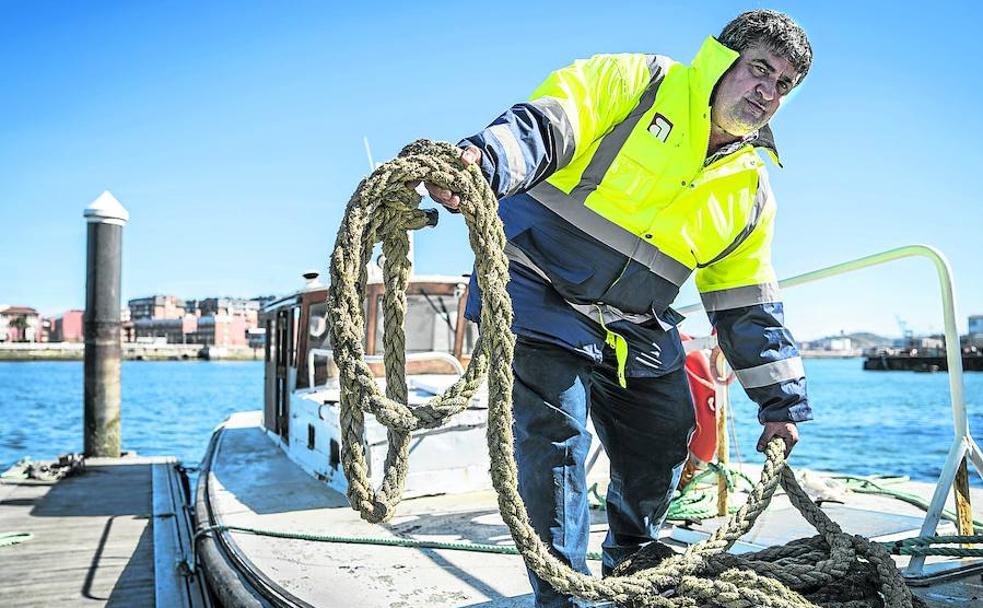 Javier sujeta la estacha a la lancha de amarradores en el Muelle Viejo de Portugalete.