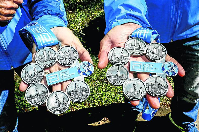 La pareja muestra la medalla de las World Marathon Majors.