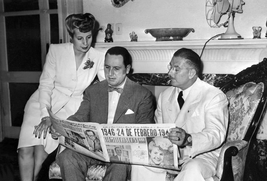 Eva Perón y su marido junto al Coronel Mercante leyendo el periódico. 