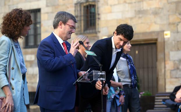 Rementeria coloca el micrófono a Aburto en el acto electoral de este lunes. 