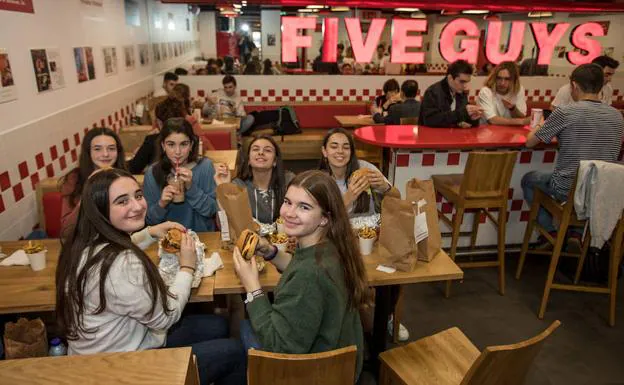 Jóvenes degustando hamburguesas y batidos. 