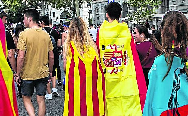 Dos jóvenes, una envuelta en la 'estelada' y otro en la bandera española, durante una manifestación estudiantil en Barcelona.