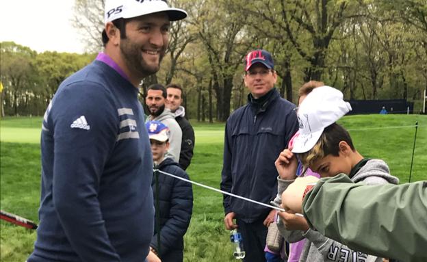 Jon Rahm saluda a un aficionado durante un entrenamiento en Farmingdale