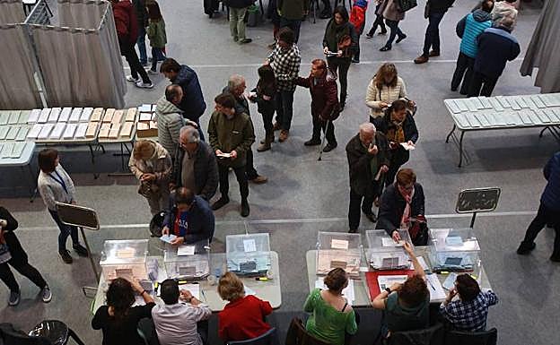Ciudadanos aguardan su turno para votar en uno de los colegios electorales de Vitoria.