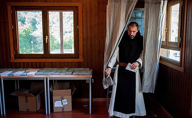 Un monje del monasterio de Oseira (Orense)sale de la cabina tras escoger las papeletas.
