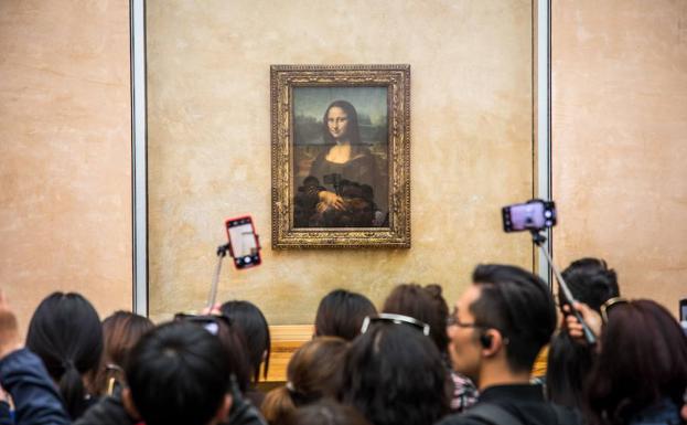 Un grupo de visitantes trata de fotografiar 'La Gioconda'.