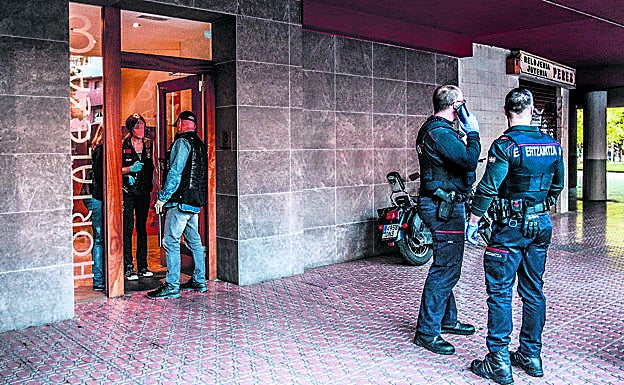 Ertzainas en el portal donde los dos sospechosos asaltaron a Pilar Arbulo.