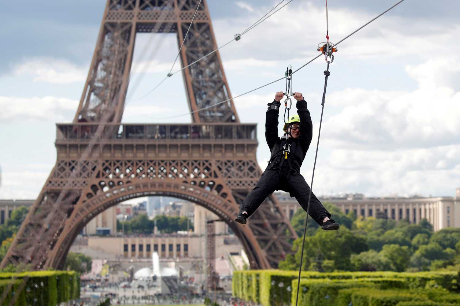 Un participante monta una tirolina desde el segundo piso de la Torre Eiffel, a 115 metros sobre el suelo, como parte del Smash Perrier en París, Francia