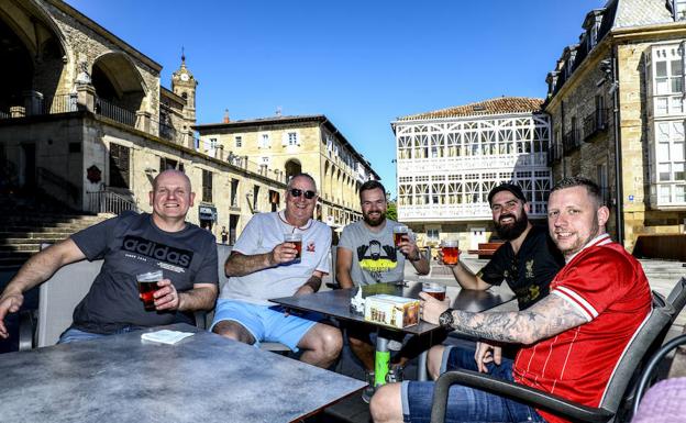 Varios seguidores 'reds' en una terraza de la plaza de la Virgen Blanca.