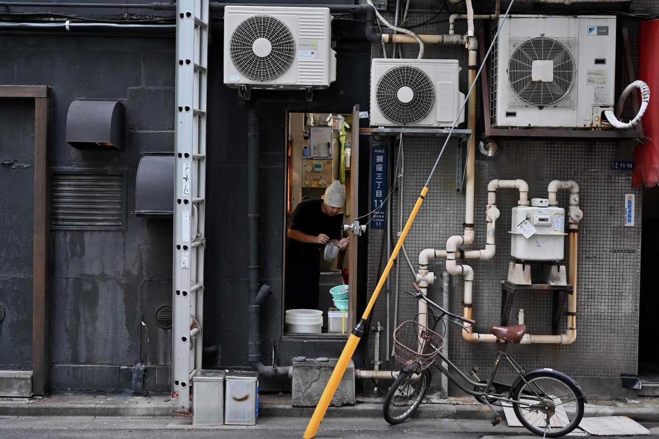 Un cocinero en la puerta lateral de un restaurante en el distrito de Ginza en Tokio