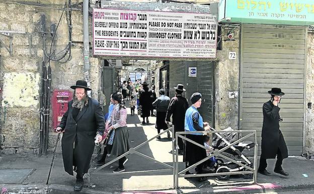 El corazón religioso. Un cartel exhorta a los forasteros a no entrar con «vestuario inmodesto» al barrio de Mea Shearim, el reducto ultraortodoxo de Jerusalén en el que viven los haredíes, 'los que temen a Dios'.