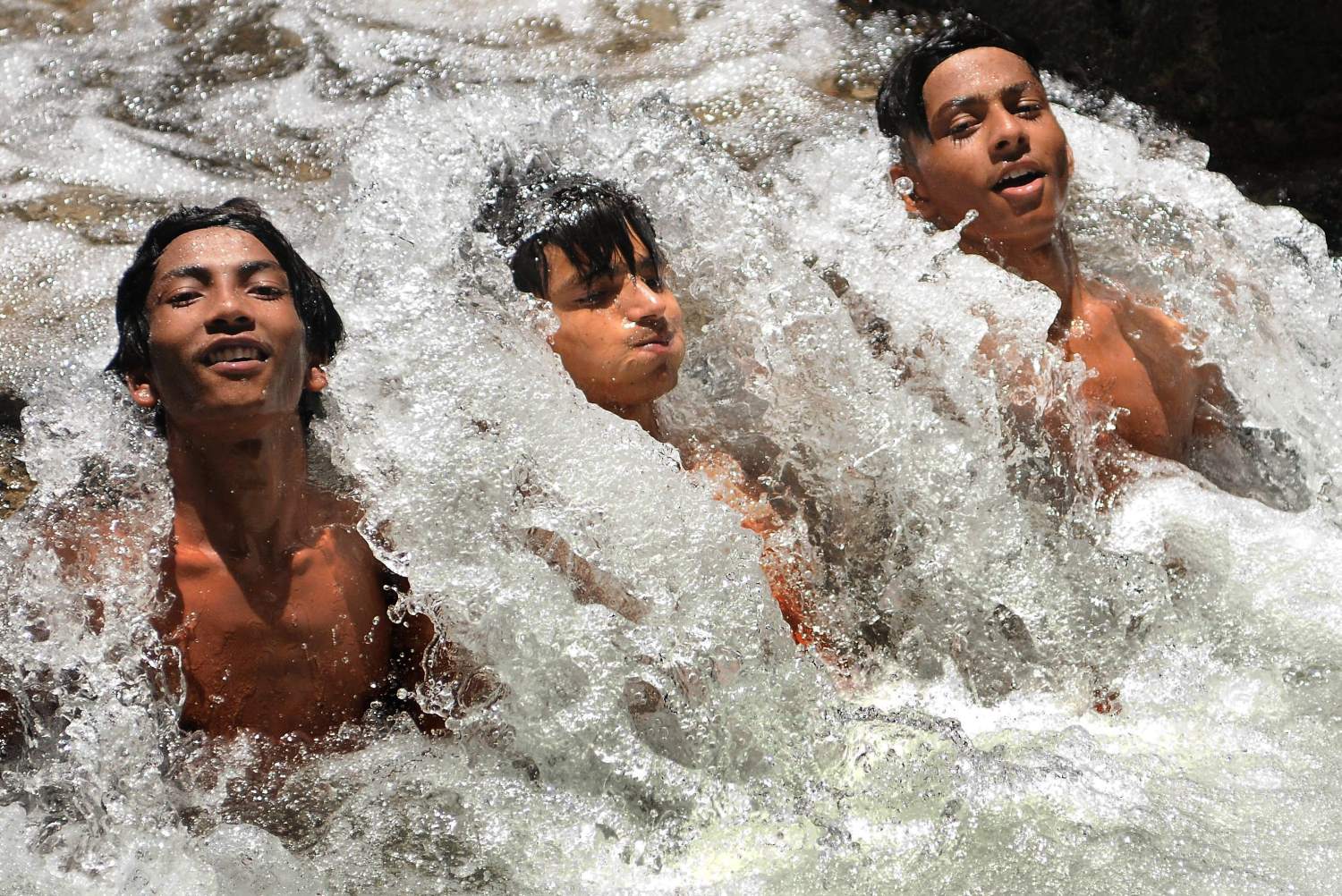 Niños se refrescan en el agua de un canal, en Nueva Delhi, la India. El pronóstico del tiempo para los próximos días apunta a que continuará la ola de calor con temperaturas máximas de 46 grados centígrados. 