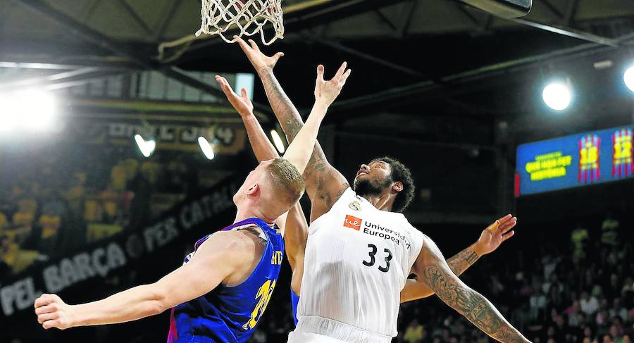 Rolands Smits disputa un balón con el madridista Trey Thompkins.
