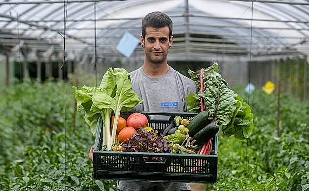Gorka Irazabal sostiene una caja con verdura recogida en sus invernaderos de Gamiz Fika.